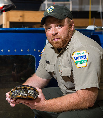 Ray Bierbower poses with a turtle from his classroom